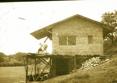 Vintage sepia-toned photo of a small, elevated wooden guardhouse with a peaked roof, likely a 20th-century border or railway ...