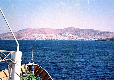 Vintage boat view of coastal cityscape with rolling hills in background. Mid-20th century seaside scene, likely Mediterranean...
