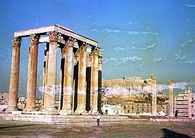 Ancient Doric columns of the Temple of Olympian Zeus in Athens, Greece, with modern buildings in foreground. Mid-20th century...