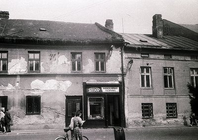 Mid-20th century urban storefront in Eastern Europe, likely Bulgaria. The building’s worn plaster and signage ("SECOOP" + "Ра...