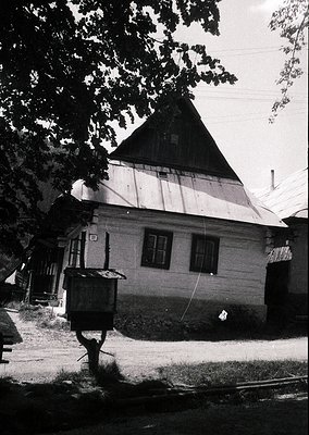 Traditional timber-framed house with steep gabled roof, likely Eastern European rural architecture. Wooden beams and plaster ...