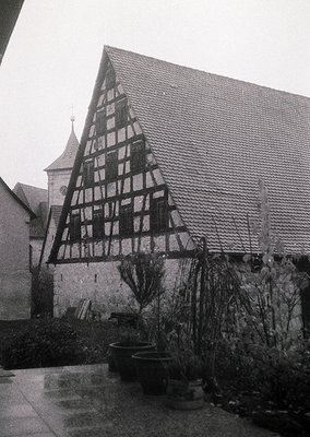 Timber-framed half-timbered house with exposed black-and-white weave, likely German Alpine or Black Forest architecture. Cour...