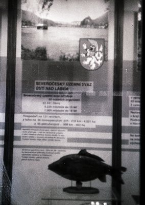 Vintage Czech railway informational board from **Ústí nad Labem**, featuring a scenic lake and mountainous backdrop. Text det...