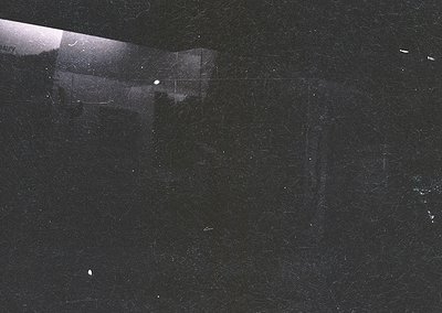 High-contrast black-and-white shot of a **mid-century modernist building corner** at night, illuminated by a single vertical ...