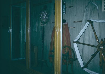 Vintage maritime display featuring a wooden ship’s wheel, rope-laden pulley system, and a traditional striped sailor’s jacket...
