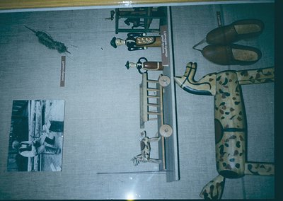 Vintage medical training mannequin with articulated limbs, ladder, and medical tools displayed on a light blue backdrop. Blac...