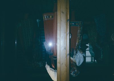 Low-angle shot of a dimly lit interior featuring traditional embroidered textiles and wooden beams. The patterned fabric sugg...