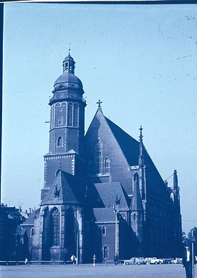 Historic Gothic Revival church with tall bell tower and pointed arches, likely 19th-century European architecture. Brick faca...