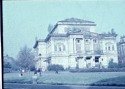 Neoclassical building with "RUSEV" inscription, likely a cultural or governmental structure from the early 20th century. Symm...