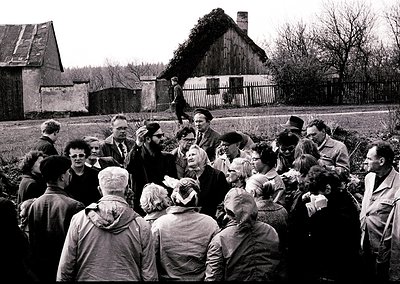 Mid-20th century rural gathering in Eastern Europe, likely –. Crowd surrounds a central speaker, possibly a local official or...