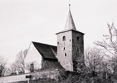 Historic stone church with pointed bell tower and steep gable roof, likely 19th-century Scandinavian architecture. Timber-fra...