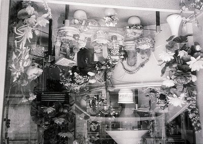 Elaborate 19th-century wedding reception hall with ornate floral arrangements, chandeliers, and mirrored walls reflecting opu...