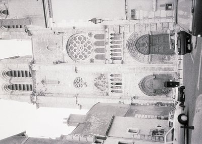 Aerial view of Gothic-style cathedral façade with rose window and pointed arches, likely 12th–16th century European architect...