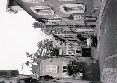 Urban courtyard framed by mid-20th century Soviet-era apartment blocks, featuring flat roofs, shuttered windows, and a centra...
