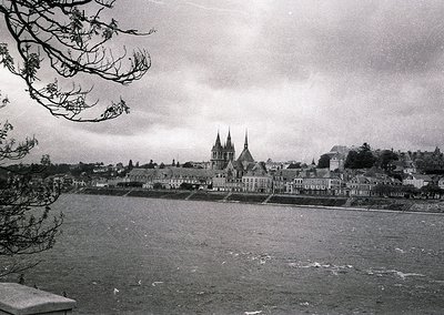 Black-and-white coastal town featuring Gothic Revival cathedral with twin spires dominating skyline. Mid-20th century archite...