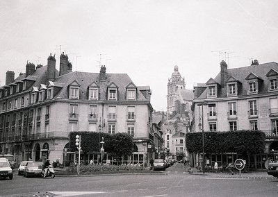 Classic European street scene featuring mid-20th century architecture. Symmetrical row of multi-story buildings with mansard ...
