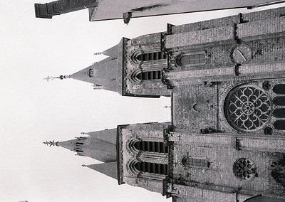 Gothic cathedral façade featuring twin spires and intricate rose window, likely 13th–16th century European architecture. Symm...
