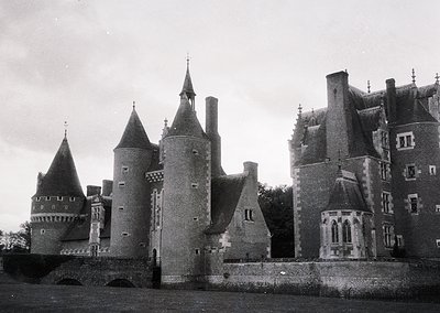 Medieval-style castle with conical towers, crenellated parapets, and arched gatehouse entrance. Architectural details include...
