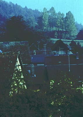 Aerial view of a rural village with distinct **traditional Bulgarian architecture**—notable for its **thatched roofs** and **...