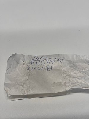 Torn aluminum foil with handwritten measurements (113.5 x 91 mm) and circled "23" in blue ink, likely for packaging or archiv...