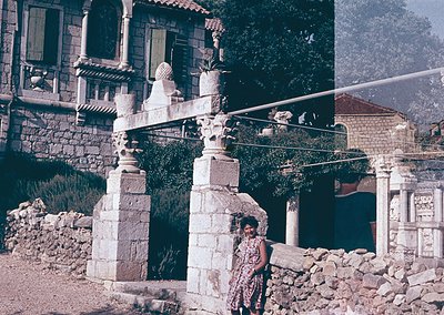 Vintage stone staircase with ornate balustrades and a woman in a patterned dress posing mid-step. Rustic Mediterranean archit...