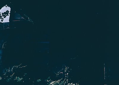 High-contrast aerial view of a coastal landscape with dark water and sparse vegetation. Distinctive white rock formation and ...