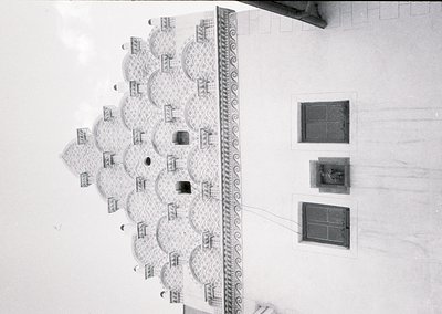 Mid-century Brutalist interior featuring geometric concrete ceiling with recessed circular alcoves. Ornate border with scroll...