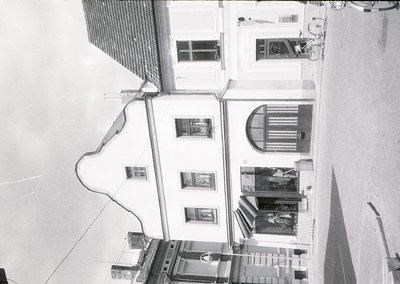 Mid-century urban courtyard with three-story residential blocks. Exposed pipes and wiring run along walls, indicating mid-20t...