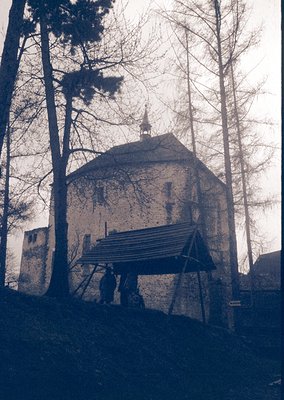 Historic stone tower with conical roof, partially covered by wooden scaffolding. Likely a medieval or early modern defensive ...