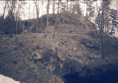 Vintage sepia-toned photo of rugged, eroded rock formations with sparse vegetation. Likely early 20th-century landscape photo...