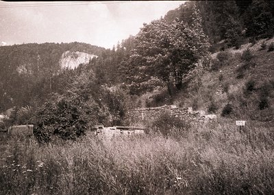 Vintage sepia-toned rural landscape featuring a rocky hillside with sparse vegetation and a narrow, winding dirt path. Foregr...