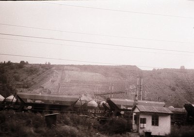Black-and-white industrial scene featuring a **collapsed railway bridge** with debris scattered across tracks. Foreground sho...
