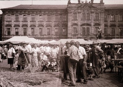Vintage outdoor market scene featuring a grand neoclassical building with tall columns and arched windows in the background. ...