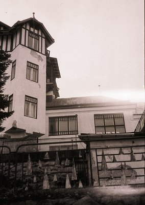 Vintage alpine resort building with Art Nouveau influences: multi-story structure featuring a corner tower with decorative br...