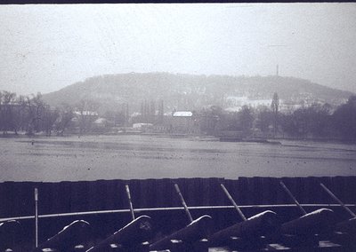 Vintage sepia-toned landscape featuring a rural scene with snow-covered fields and sparse trees. Distant hilltop with a lone ...