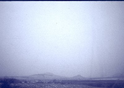Vintage sepia-toned landscape shot with indistinct, foggy horizon and faintly visible low-lying hills. Likely mid-20th centur...
