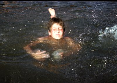 Vintage black-and-white photo of a person submerged in water, holding a spherical object. The dynamic motion blur suggests ra...