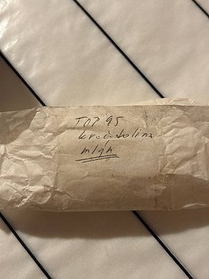 Handwritten label on crumpled paper: "TOP 95 Kred Solina m1gh." Suggests a vintage or collectible item, likely related to **K...