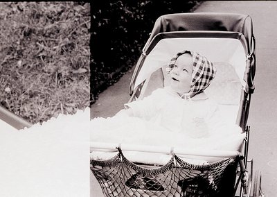 Vintage black-and-white photo of a child in a vintage pram with a woven mesh basket, likely mid-20th century. The child wears...