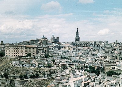 Vintage aerial view of Toledo, Spain’s historic hilltop city. Prominent Gothic cathedral spire and Romanesque church domes do...