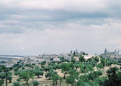 Vintage aerial view of Seville’s historic skyline, featuring olive groves in foreground and iconic cathedral spires (). Mid-2...
