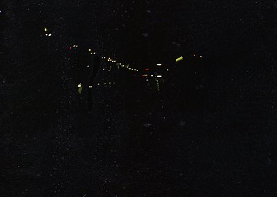 Nighttime aerial view of a sleek, elongated aircraft in flight, illuminated by green and white navigation lights. The design ...