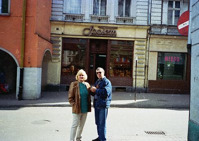 Vintage photo of two individuals posing outside a storefront labeled "Joodem" in a European city, likely 1970s–1980s. The bui...