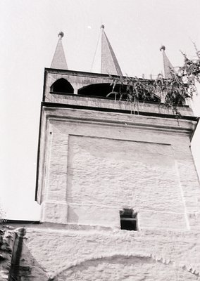 Historic stone tower with pointed conical roofs and arched ventilation openings, likely part of a fortress or monastery. Arch...