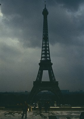 Silhouetted Eiffel Tower under stormy skies, Paris, 19th-century iron architecture. Minimalist composition highlights the tow...