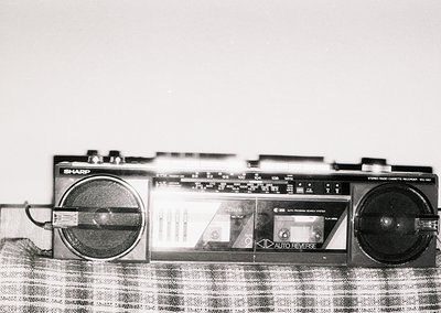 Vintage Sharp EL-562 portable cassette recorder with dual speakers, analog tuning dials, and "Auto Reverse" feature. Mid-20th...