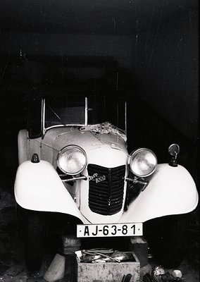 Classic 1930s–1940s **Alfa Romeo 6C 1500** convertible, captured in dim indoor lighting. Distinctive streamlined bodywork, du...