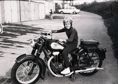 Mid-century vintage motorcycle rider in protective gear, likely 1950s–1960s. Classic CWK or CWK-style bike with chrome detail...