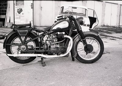 Classic **AJS Model 20/25 sidecar motorcycle** (1950s–1960s) with exposed V-twin engine, pressed-steel fenders, and spoked wh...