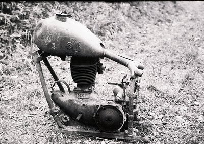 Vintage NSU two-stroke motorcycle engine, likely mid-20th century, displayed outdoors on grass. Rust and wear indicate prolon...